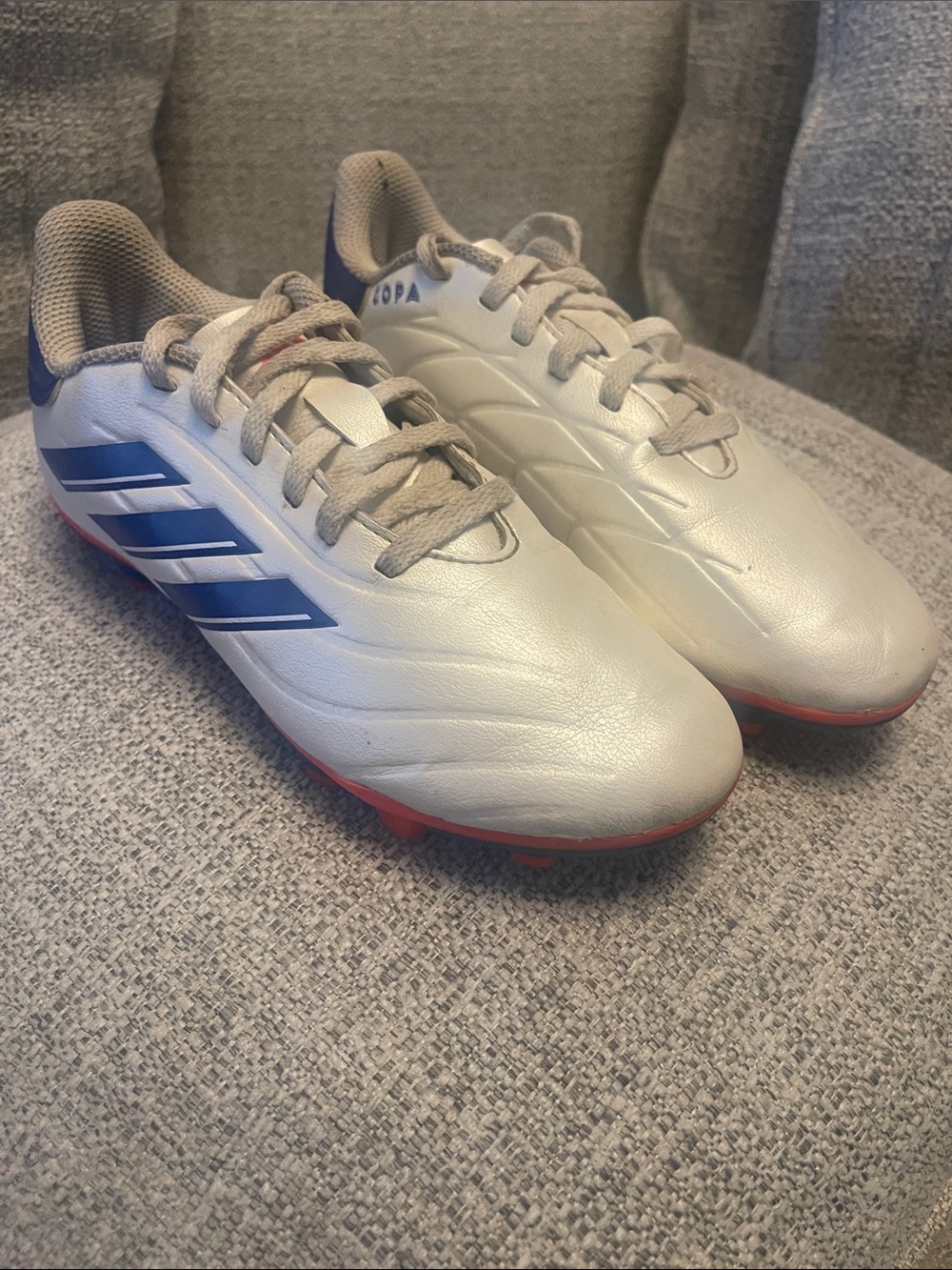 adidas White Soccer Cleats with Blue Stripes and Red Outsole